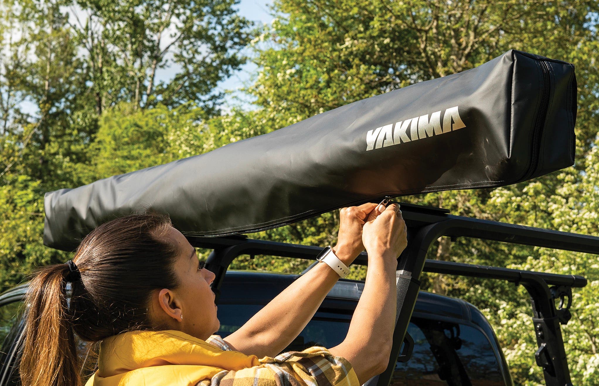 A truck-mounted shade tent rolled up into its carrying case