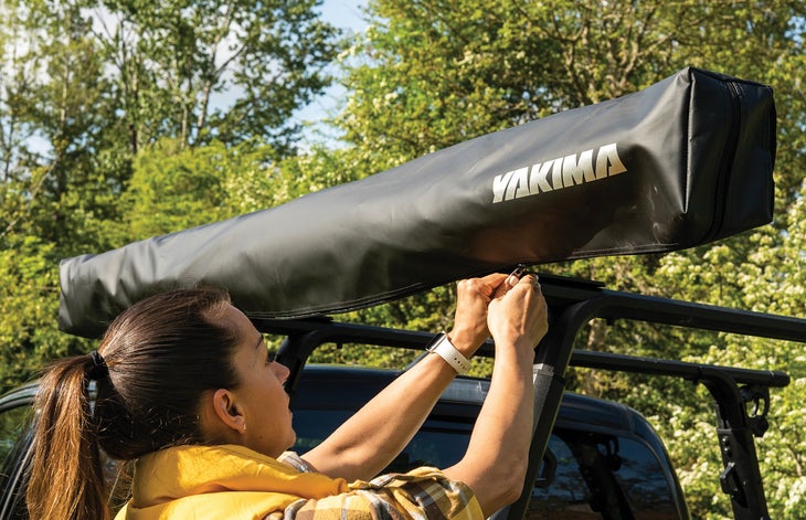 A truck-mounted shade tent rolled up into its carrying case