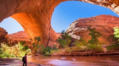 A hiker at Jacob Hamblin Arch in Coyote Gulch, Grand Staircase-Escalante National Monument, Utah, United States to demonstrate the solitary way