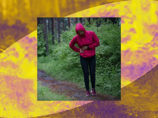 A person in a red raincoat holds their side