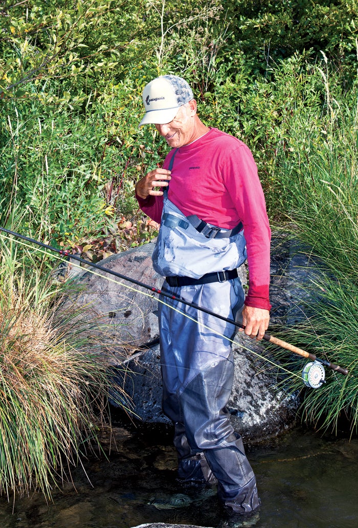 A athletic man fly fishing stands in a … – License image