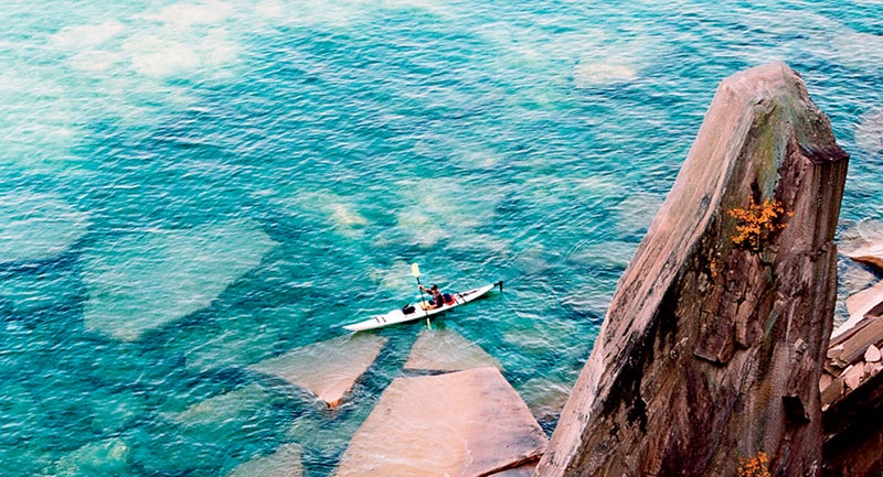 A sea kayaker passes sail rock in Pictured Rocks National Lakeshore.