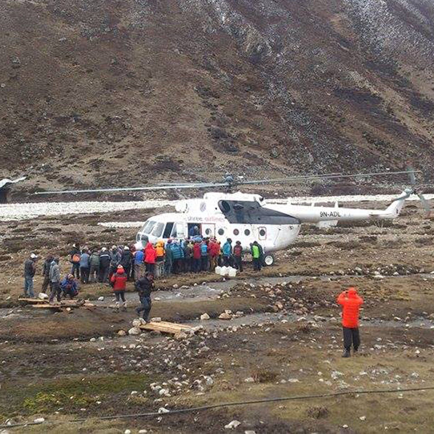 Mountaineers and Nepalese Sherpa guides evacuated from Everest Base Camp wait to board a rescue chopper to be flown to Lukla, in Pheriche, Nepal, Sunday, April 26, 2015. Mountaineers, guides and porters streamed from Mount Everest base camp on Sunday in the wake of a deadly earthquake-triggered avalanche that obliterated parts of the rocky village of nylon tents. Some warned that dozens of people may still be missing. (AP Photo/Pasang Dawa Sherpa)