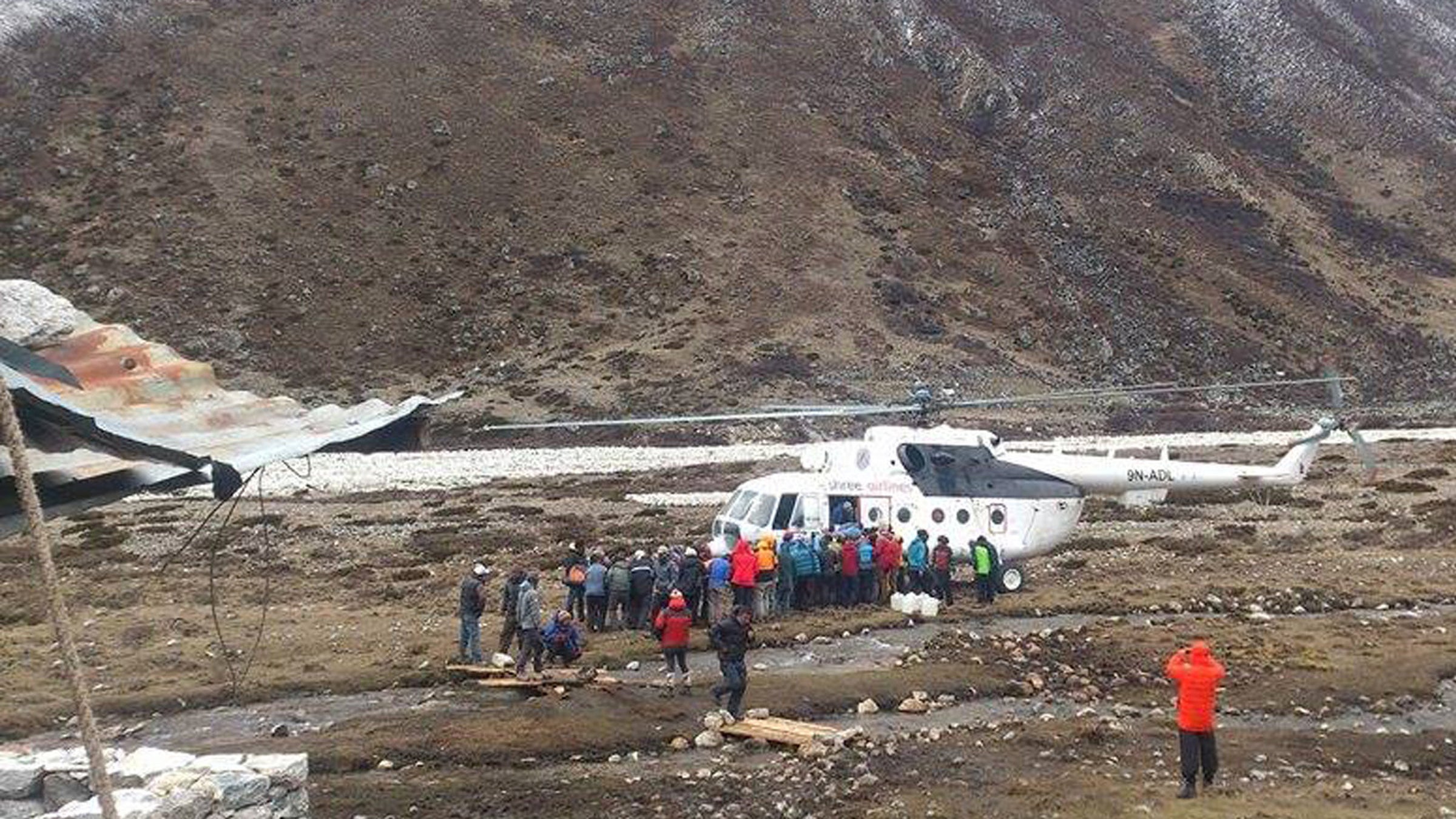 Mountaineers and Sherpas wait to board a rescue chopper to be flown to Lukla, in Pheriche, Nepal, on Sunday, April 26.