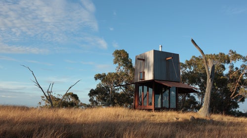 Located on a remote mountain, the tower features a mere 9 square-meter footprint and has panoramic surrounding views for hundreds of miles. When not in use, the awnings flip down to completely enclose the timber and glass interior and protect it from the elements. The building was constructed in Sydney, Australia, then transferred to its isolated home.