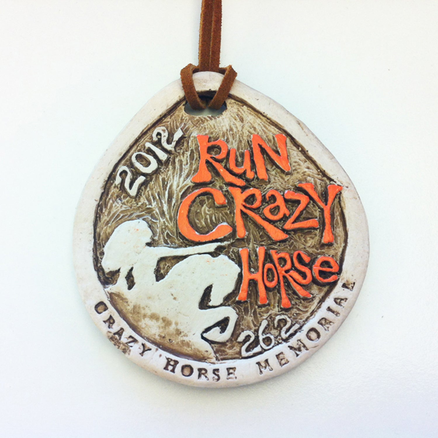 Solera: I love this medal’s grit and chiseled shape, even though the design borrows very heavily from the Big Sur International Marathon medal. It features the event’s titular sculpture, with Crazy Horse himself pointing forward, as if directing runners to follow the 26.2-mile path to glory. Made from clay and featuring a hand-tied leather strap, you might suspect your medal was the only one made.