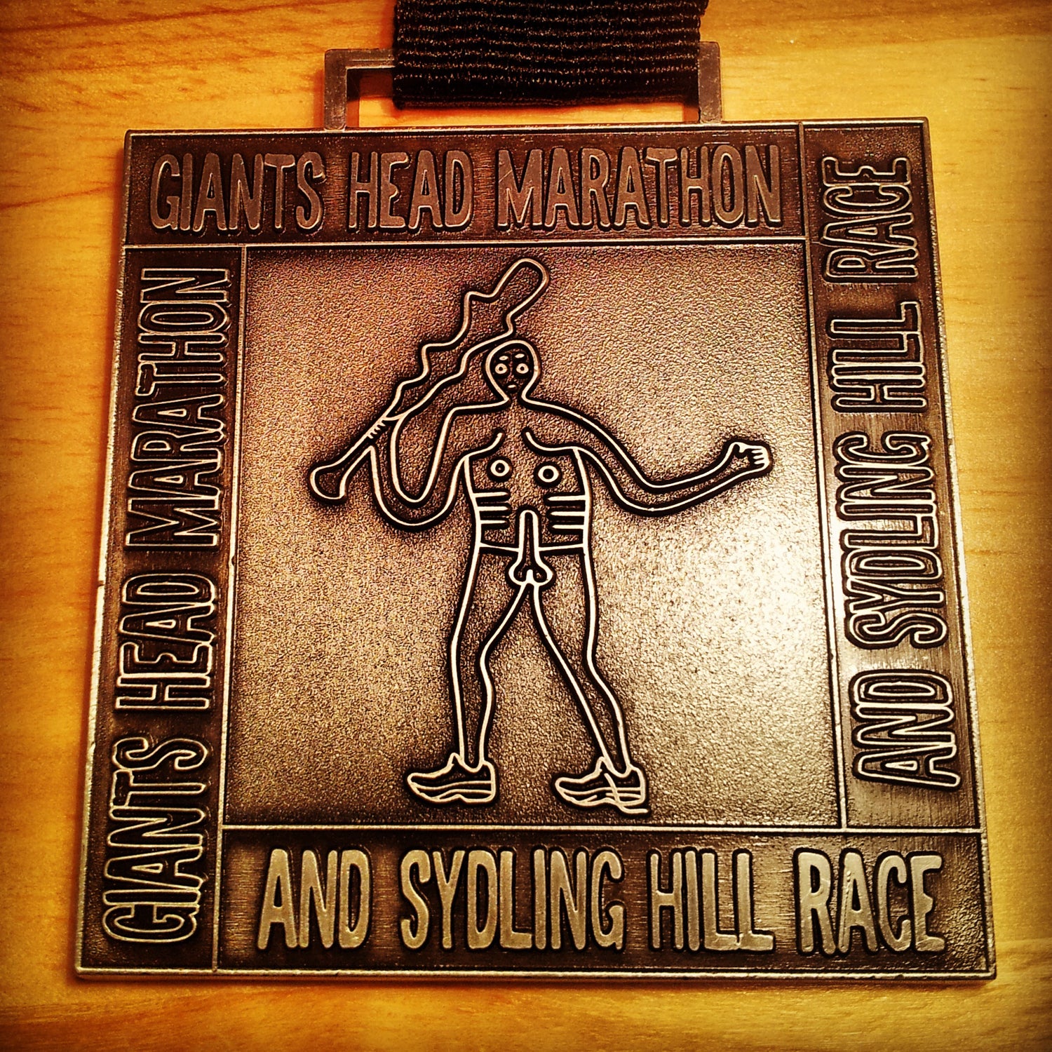 Williams: Speaking of male genitalia, the next medal was fabulous enough to make me sign up for the (slightly long) marathon despite it’s hellish elevation profile. The Giant’s Head Marathon, in Dorset, takes place in the beautiful English countryside, including the historical Cerne Abbas Giant, a giant chalk drawing on a hillside. The Cerne Abbas Giant features prominently on the medal, including his prominent member. It’s also a weighty piece of hardware and a challenging day out. Bonus: At (roughly) 20 miles, there is a “Love Station,” which features tray bakes, cake, sandwiches, cider, and flavored vodka.Fun fact: The weekend was so filled with innuendo that I genuinely asked for the “spicy penis sauce” instead of the spicy peanut sauce the following day in a restaurant.