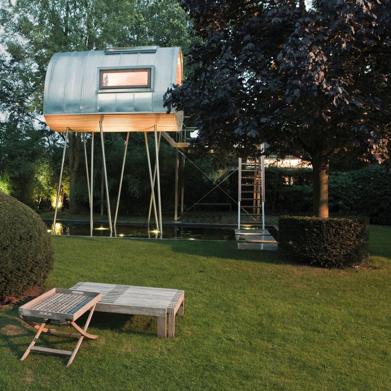 A narrow walkway and a few steps allow access to the treehouse, resting on eight asymmetrical steel supports. Large windows on each side of the structure and a convex skylight on top allow in abundant light. A few months after construction was complete, amphibians began to move into the pond below. Today, you can fall asleep to the setting sun with the sound of croaking frogs beneath.