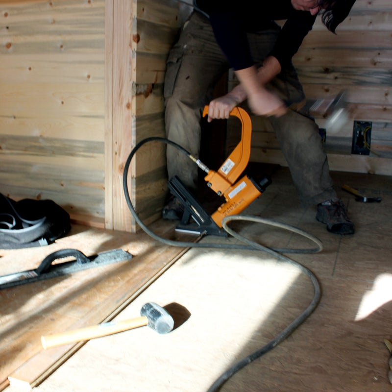 At the start of the project, the couple planned to purchase only the essential tools. But they “quickly learned that buying tools and always having them on site ends up saving you tons of money and time,” says Smith. It’s good to have at least one spare hammer, screwdriver, and electric drill nearby. Here, Christopher manhandles a flooring stapler, a specialized tool they rented for a few days.