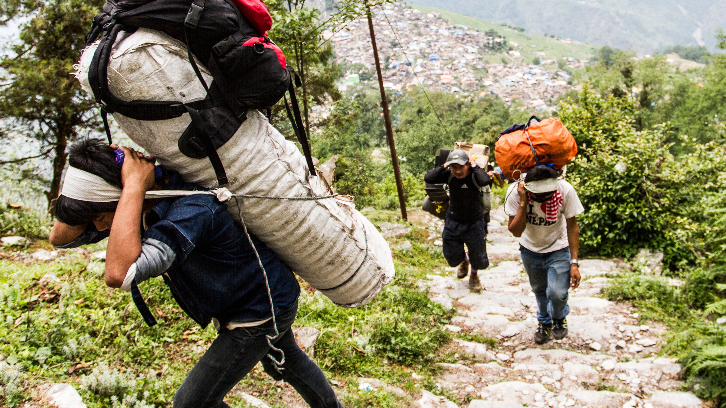 Thirty-six porters hired by Oxfam deliver relief material by foot to the remote village of Laprak.

