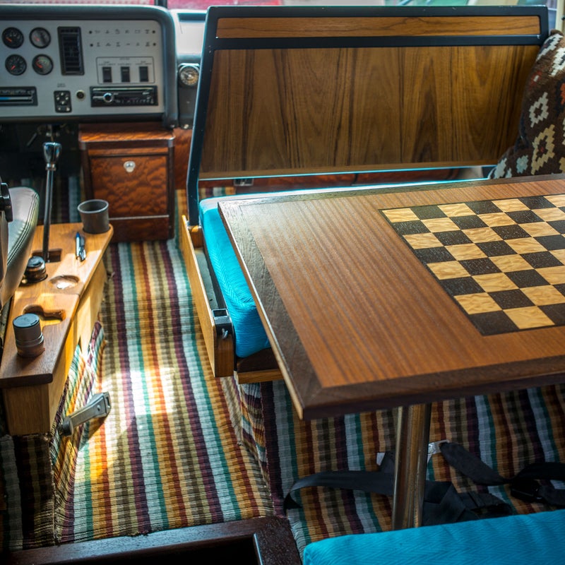 I had much of the interior rebuilt using fine wood (teak, sapele, and wenge) as well as fabrics and carpeting. The front passenger seat flips downward, revealing an inlaid table at which to eat or play chess.