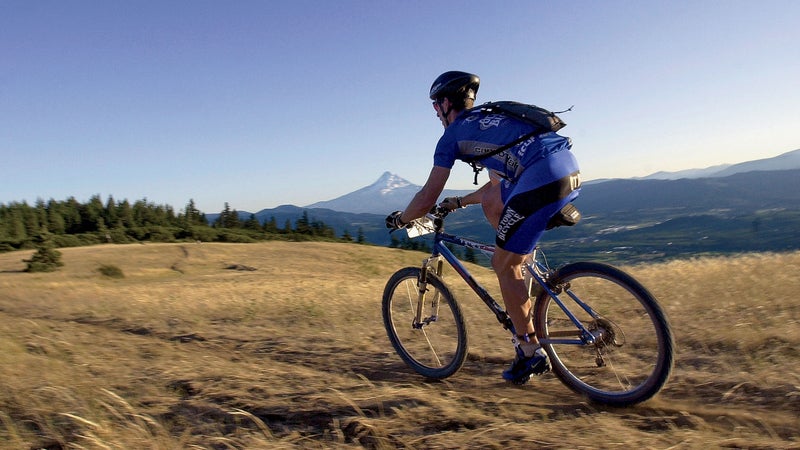 20 Jul 2002, Hood River, Oregon, United States --- A rider races down the trail just before sunset in the 24 hour mountain bike marathon during the Gorge Games. --- Image by © Tony Wayrynen/NewSport/Corbis