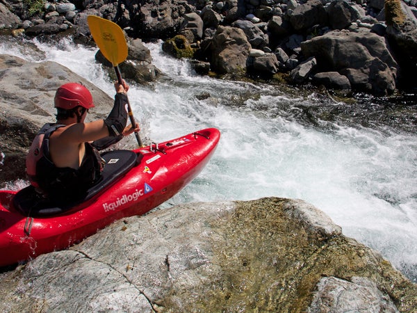 woman dropping into a river in one of the best kayaks