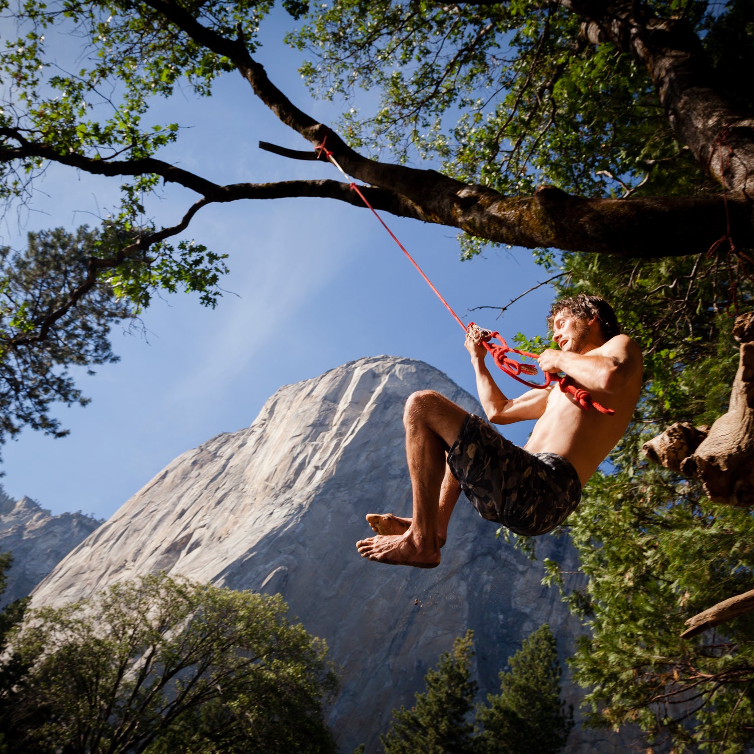 Peter Moore takes a day off from climbing and takes a swing on the rope at a swimming hole in Yosemite National Park.  El Cap looms in the background
