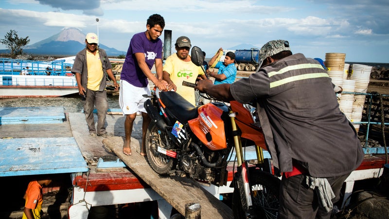 Workers unload the author's motorcycle from a ferry at the port city of San Jorge, on the shores of Lake Nicaragua.