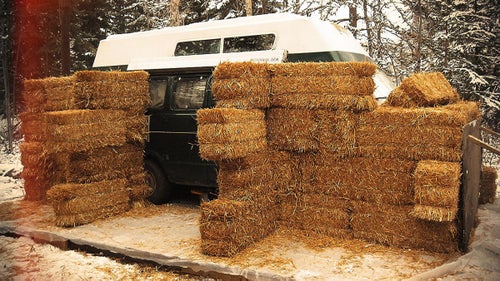Stacking the hay bales like building blocks, Eastbound spent a day covering the van.