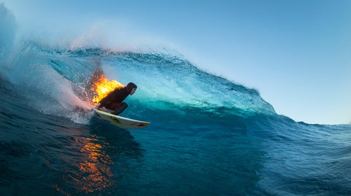 Jamie O’Brien surfs while lit on fire at Teahupo’o, Tahiti, on July 21, 2015.