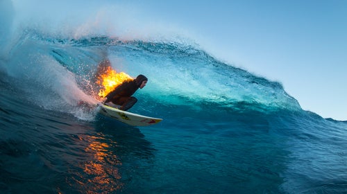 Jamie O'Brien surfs while lit on fire, at Teahupoo, Tahiti in July.