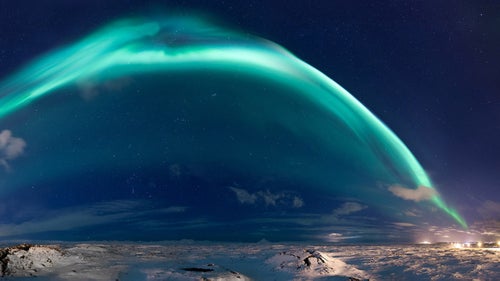 This image by Icelandic photographer Sigurdur Brynjarsson displays a 180-degree view of the aurora borealis during a December 2014 night in Iceland. The dome of the Northern Lights can be seen stretching from the city of Reykjavik (right) to the town of Keflavik to the west (left).
