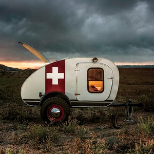 Trailer features include a storage boot for your camp kitchen, a five-by-eight-foot cabin with memory foam mattress, and a torsion axle with moon hubcaps and off-road tires.