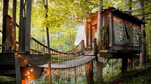 Suspension bridges connect three separate structures: a living room, bedroom, and deck.