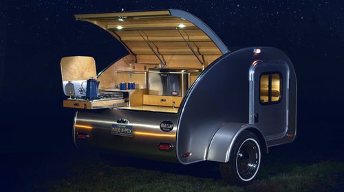 The High Camp Trailer comes with an outdoor kitchen and quilt-top mattress.