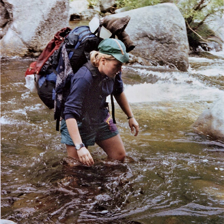 Molly crossing a stream with all of her gear in water up to her knees