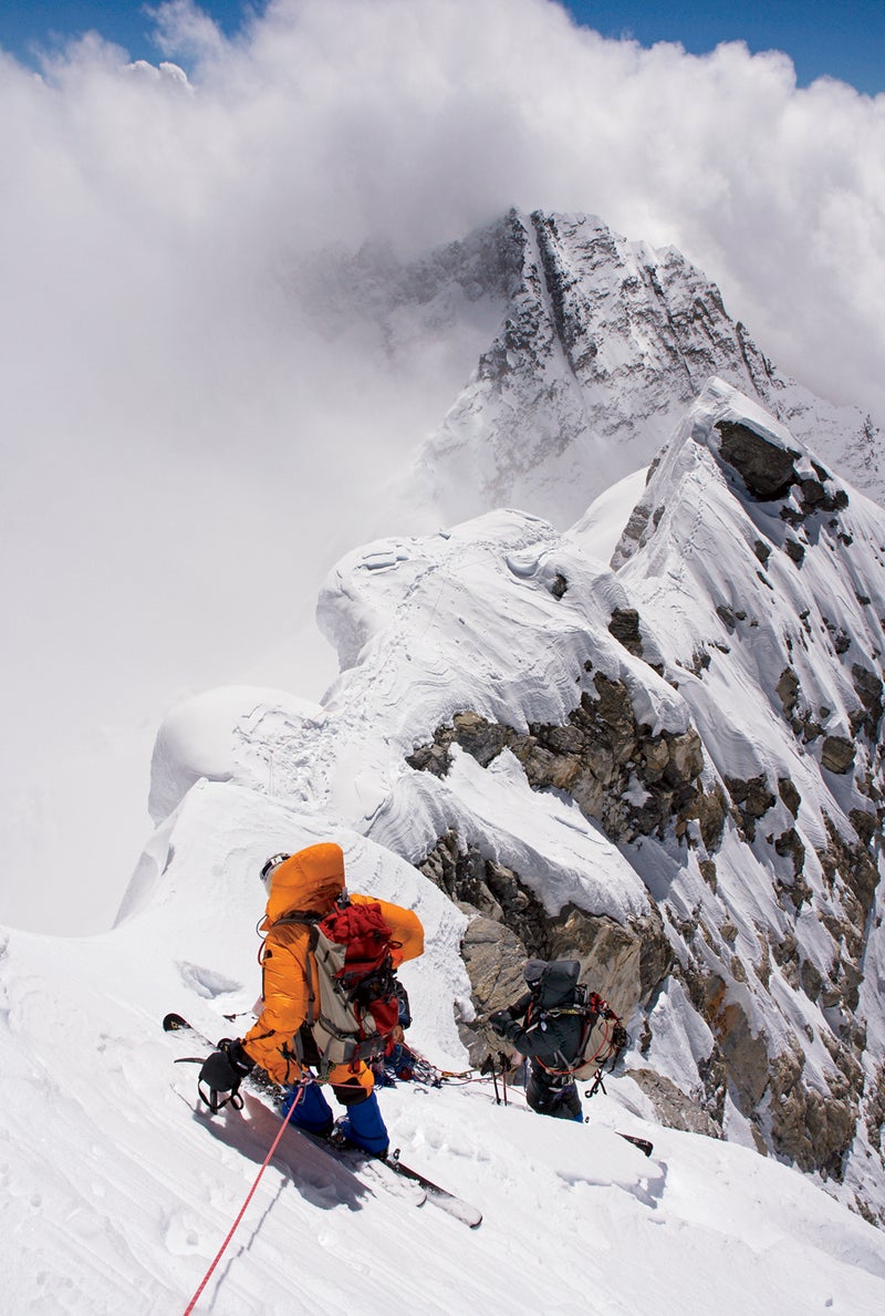 After skiing the summit ridge, Kit waits above the Hillary Step at 28,800 feet for husband Rob, in black, right to ski-rappel around the 40-foot cliff.