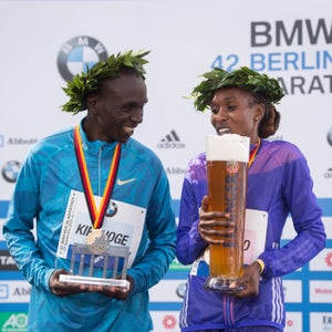 Winners Eliud Kipchoge (left) and Gladys Cherono (right) celebrate their victory on the podium during the 42nd Berlin Marathon. Kipchoge ran the eleventh fastest marathon in history.