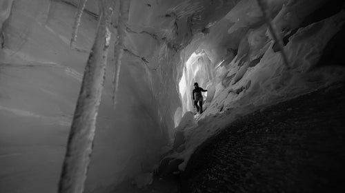 ​The North Face athlete and German alpine climber ​David Göttler exploring an ice cave in the icefall above​ the village of​ Kyanjin Gompa​, in the Langtang Valley.