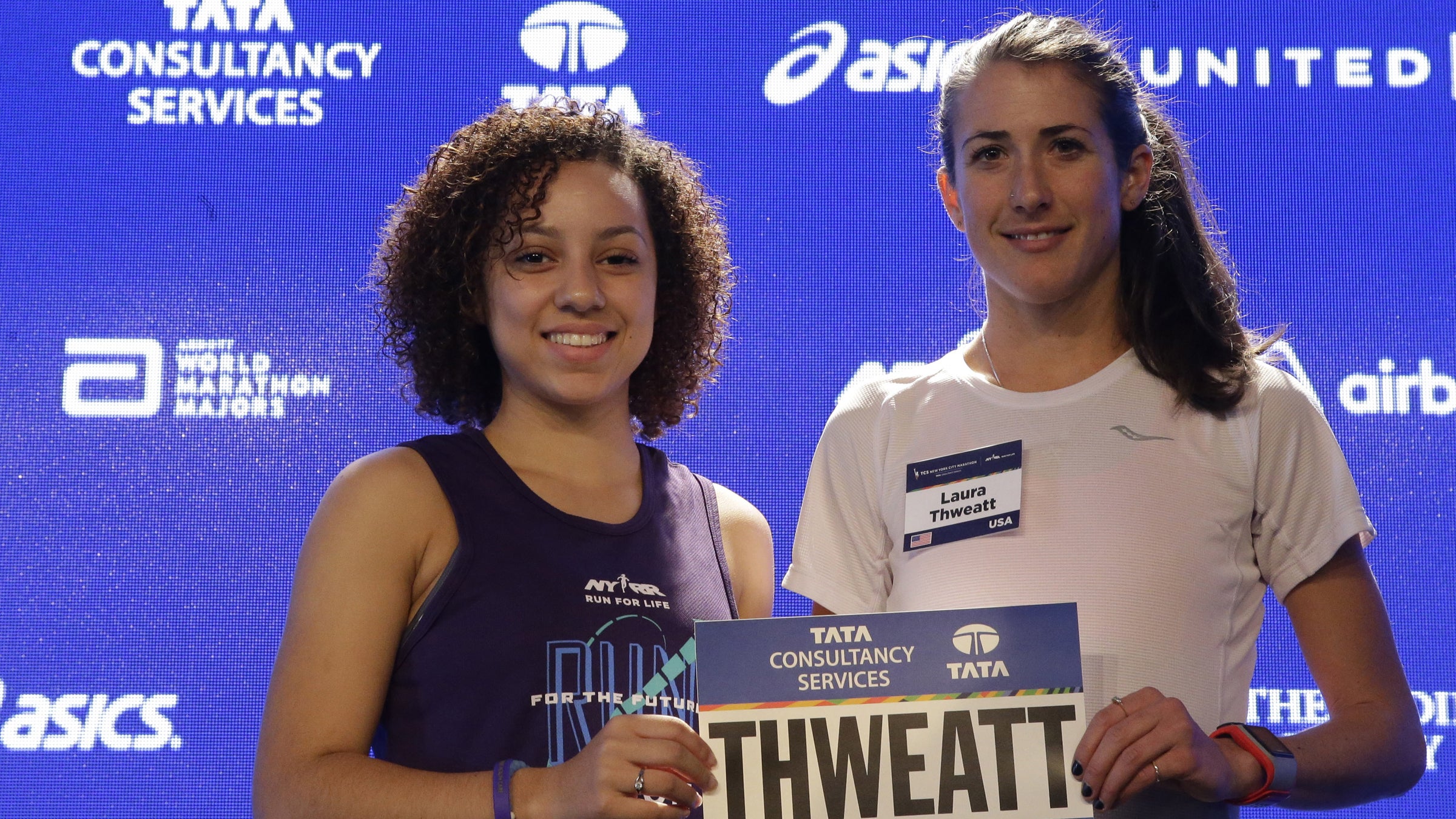 Run for the Future participant Carolyn Navarro, left, presents Laura Thweatt her New York City Marathon bib on October 30.