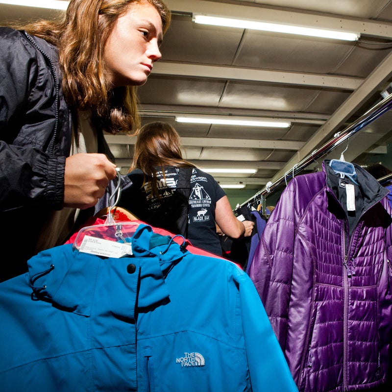 A shopper nabs a shell from The North Face and a puffy from REI, both for $35.99.