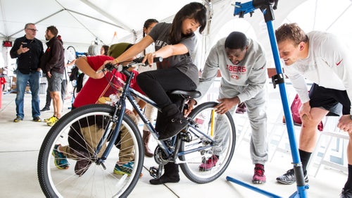 Lelani's bike gets a final inspection from two 49ers 