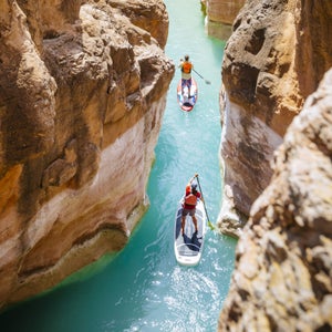 Jon Imhoof and Sabina Allemann paddle stand up paddleboards on Havasu Creek near its junction with the Colorado River, Grand Canyon National Park, Arizona, USA