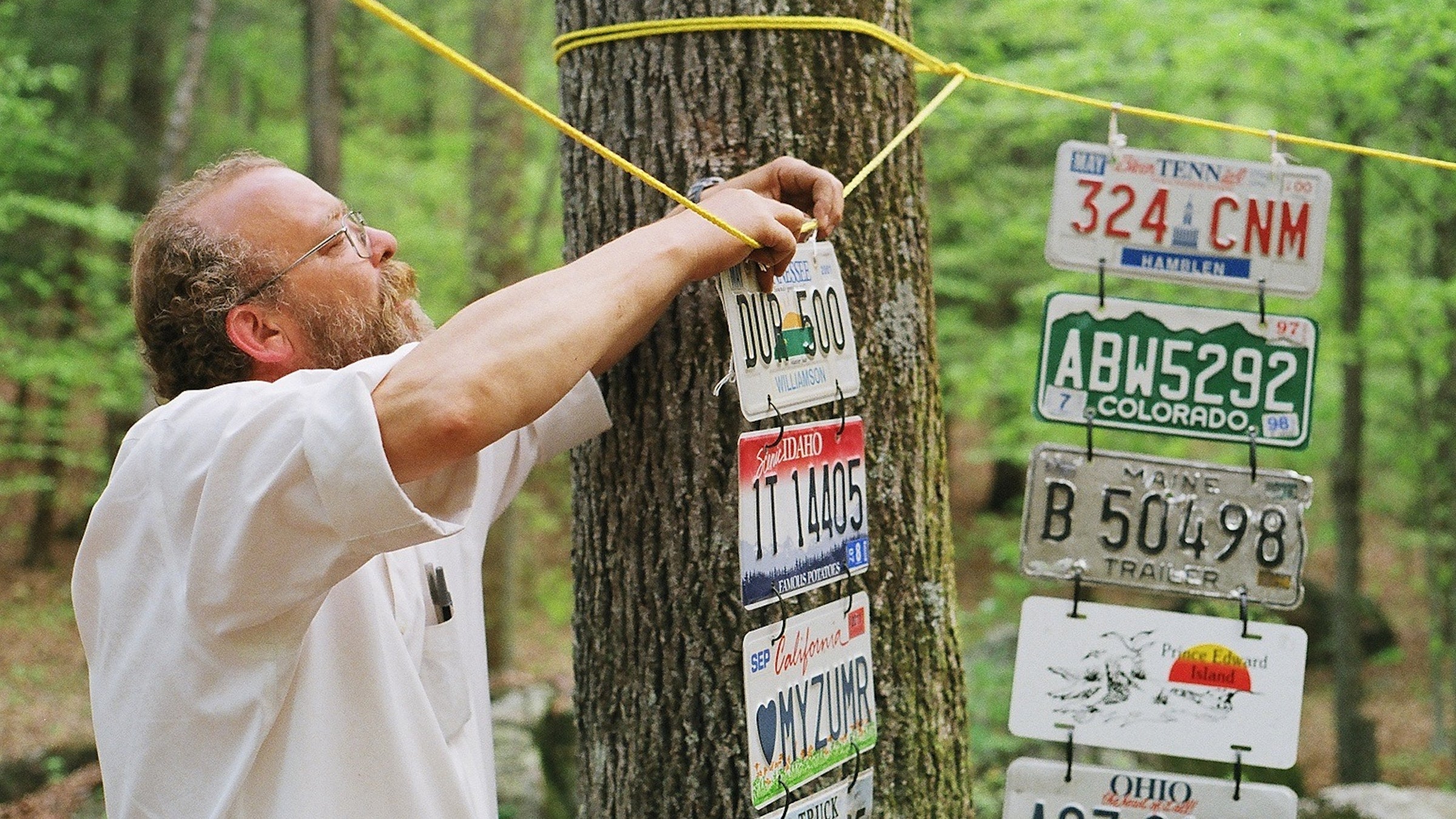 Lazarus Lake, cofounder of The Barkley Marathons, hangs one of the required entry items, a license plate from the runner's home state or country. Other requirements include a flannel shirt and the application fee of $1.60.
