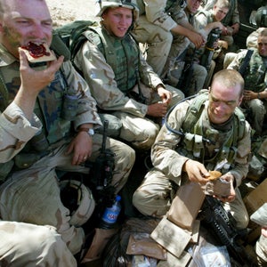 U.S. soldiers from the 173 Airborne Division eat MRE's and sit packed into a truck, shortly before pulling out after an operation in Hawija, northern Iraq, Tuesday, May 20, 2003. Hawija is known by many Iraqis to have been a major base for Baath Party leaders and a base of operation for Iraqi secret police.  (AP Photo/Brennan Linsley)