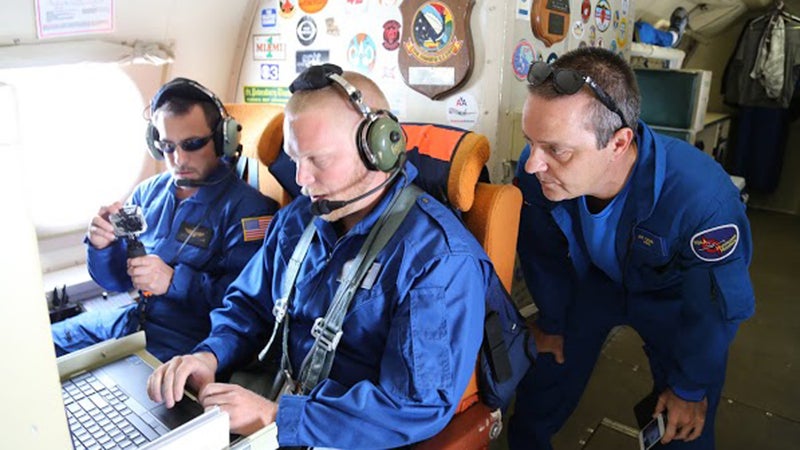 Drew Osbrink and Eric Redweik of Sensintel and NOAA hurricane researcher Joe Cione monitor data from the Coyote as it flies into Hurricane Edouard.