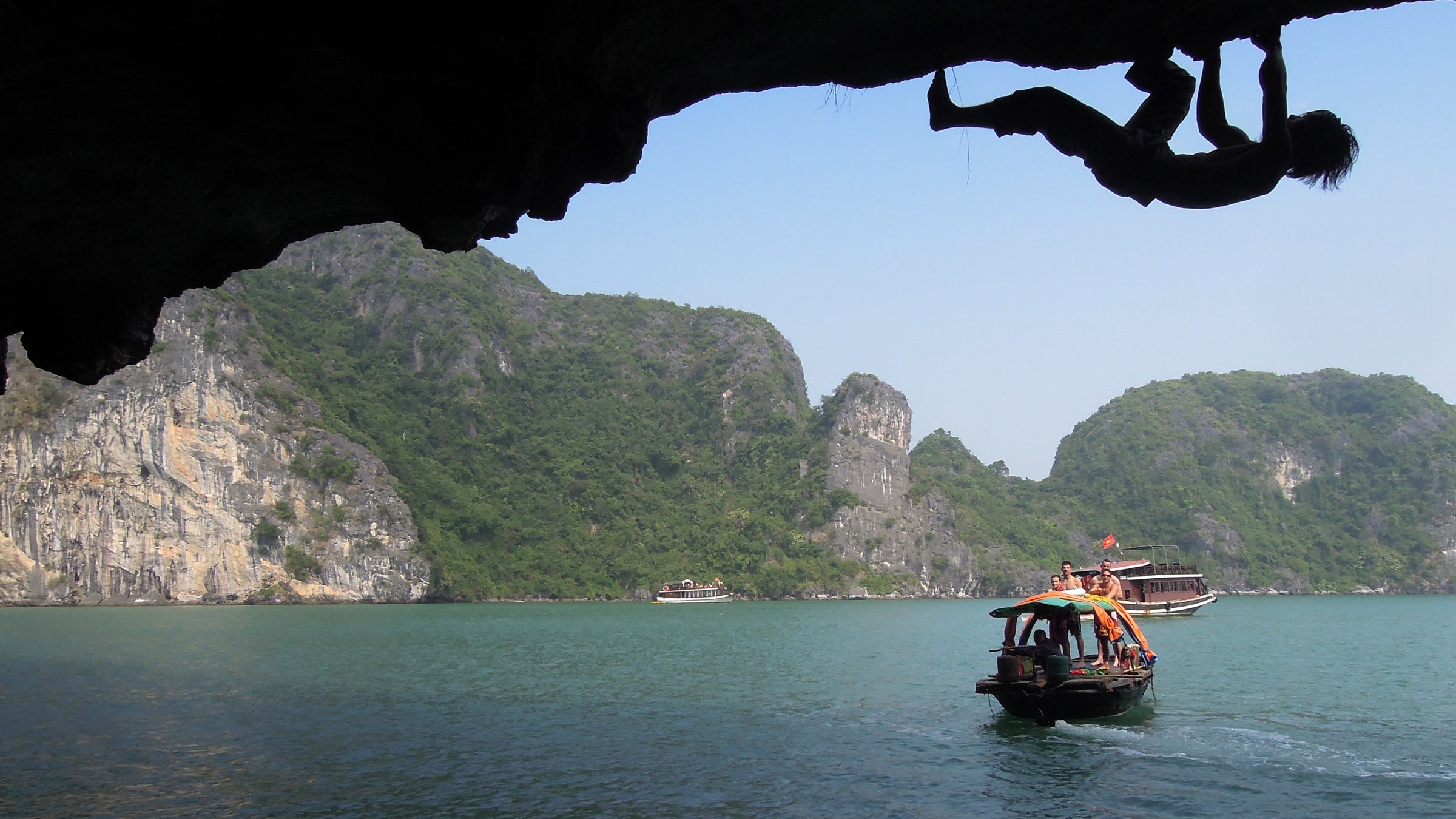 Nguyen climbs slick limestone over the waters of Cat Ba Island in Ha Long Bay.