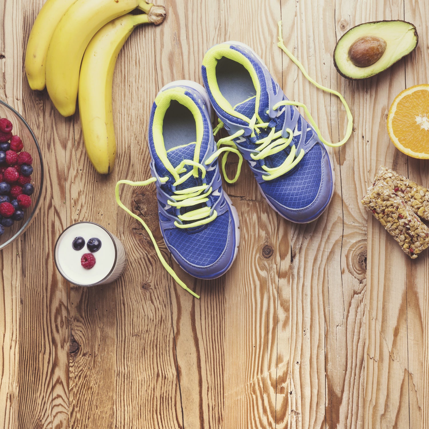 Pair of running shoes and healthy food composition on a wooden table background