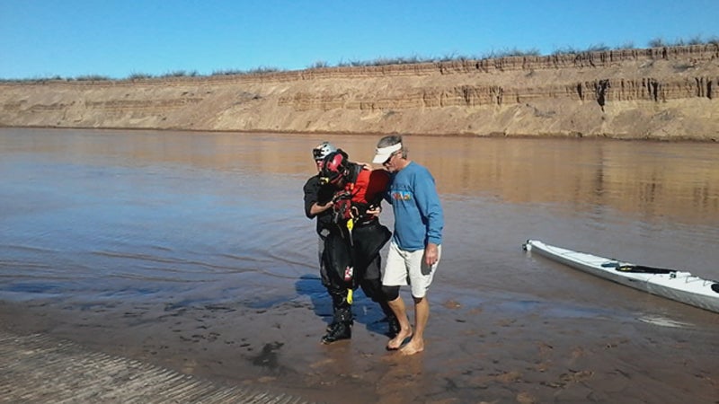 Ben Orkin is helped to the riverbank after his epic paddle.