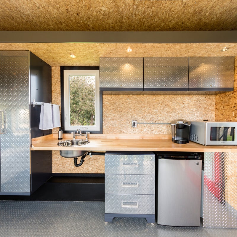 The kitchen is simple, with locking steel cabinets, drawers, and an armoire to store provisions and kit. There鈥檚 also a compact fridge, induction cooktop, and microwave.