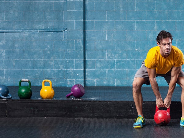 man training with a kettlebell