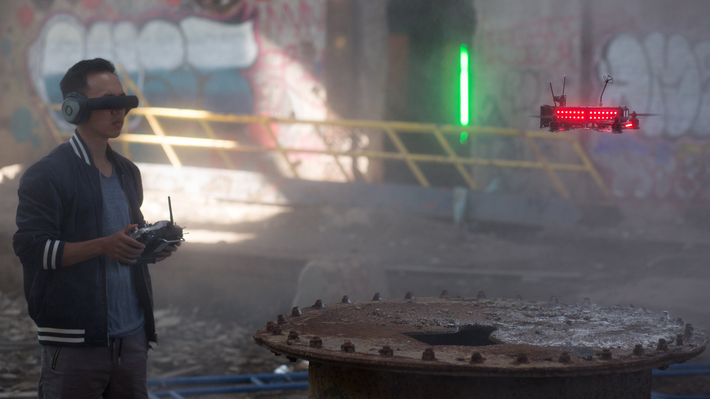 Drones race through neon-lit gates and up staircases doing 80 mph.