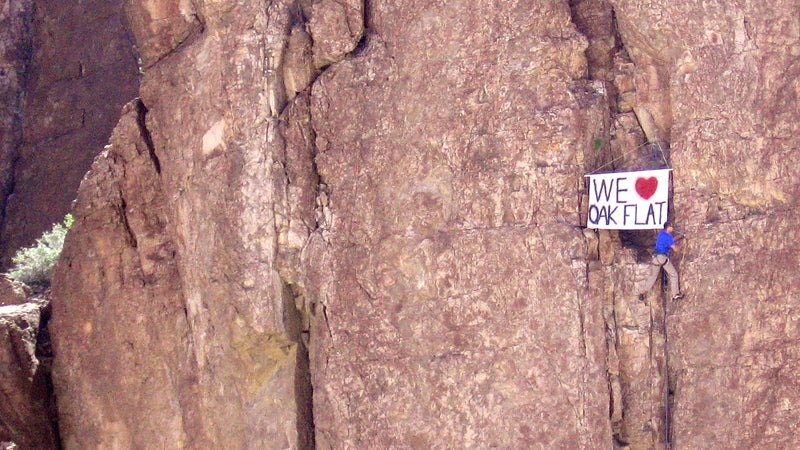 Manny Rangel posts a sign on a climbing route in Oak Flat.