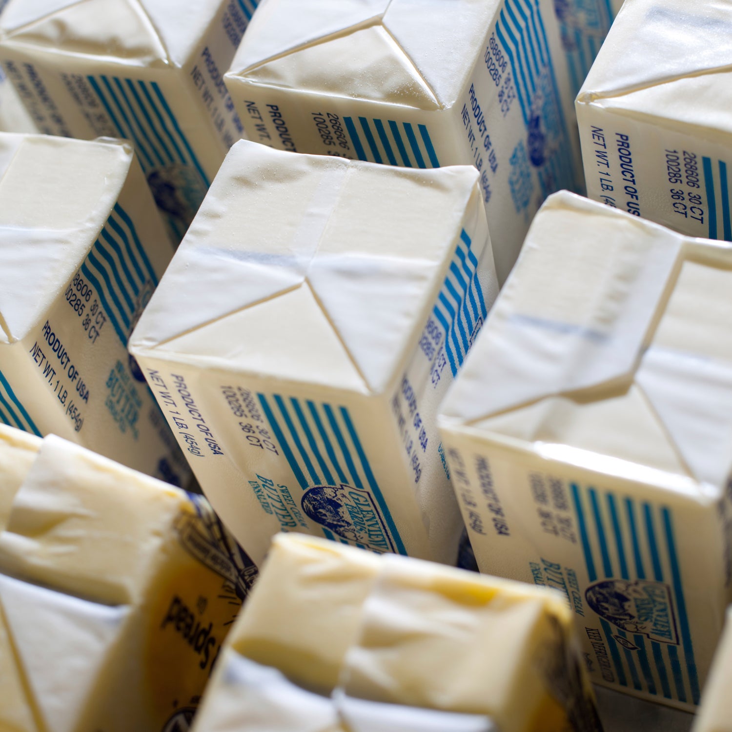 pounds of butter lined up in row on a table.  The butter is being warmed up to room temperature for a commercial baker.