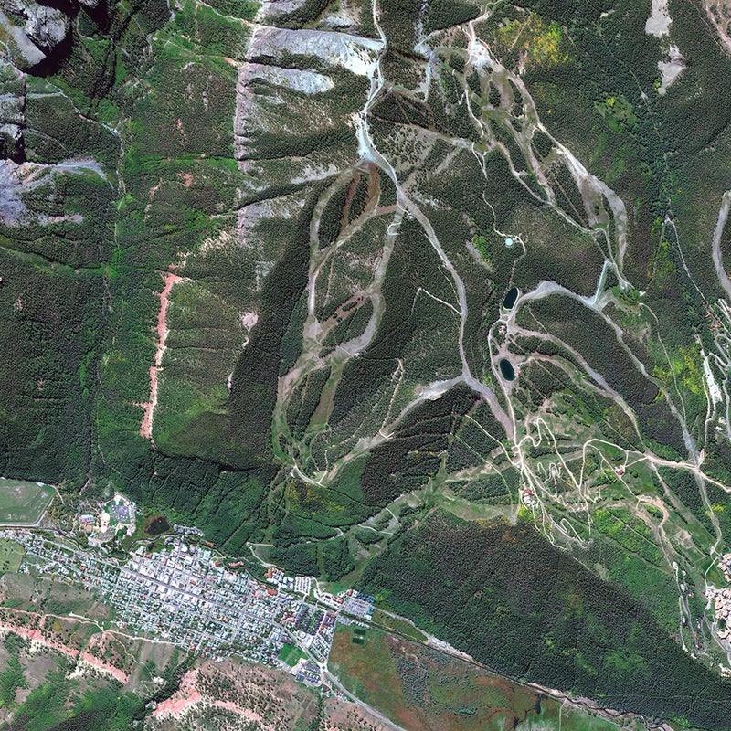 This image of old Colorado mining town was captured in September 2012, just before the aspens changed color that year. The town is set in a box canyon in the heart of the San Juan Mountains, which contain the highest concentration of 13,000- and 14,000-foot peaks in the Lower 48. The photo shows the small spur of the ski area just above town, spackled with black diamond pistes that deliver skiers into town via any one of a number of famed bump runs, including Bushwacker, Kant-Mak-M, and Lower Plunge, visible in the center of the photo.