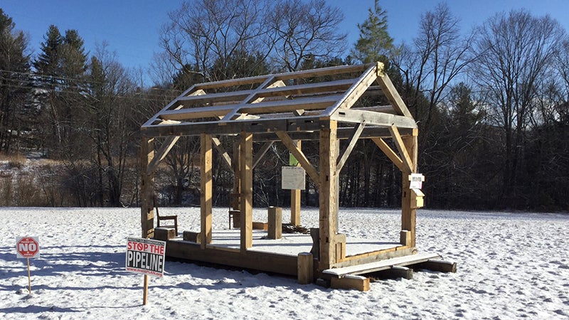 The framed cabin, as it stands now in a hay field.