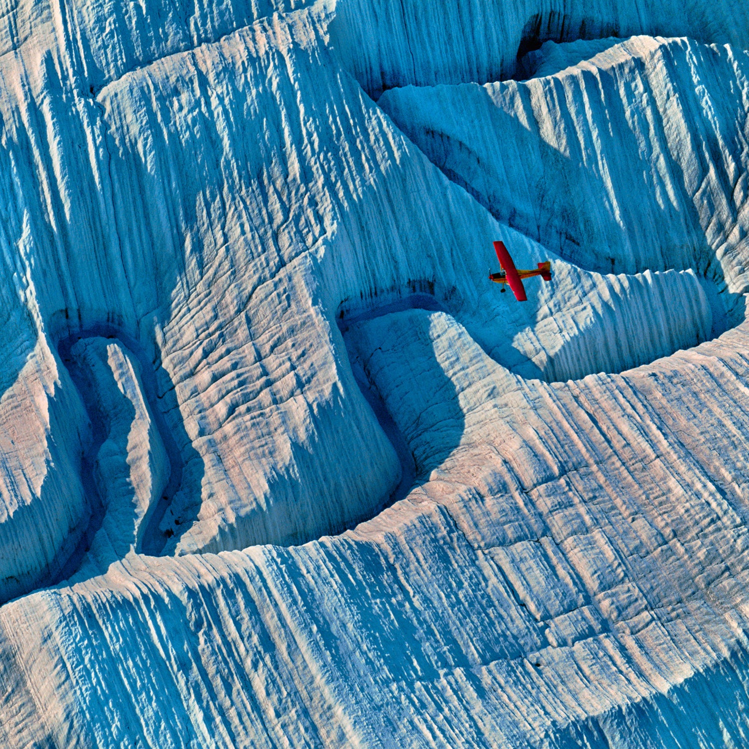 A bush plane flies over a glacier in Wrangell-St Elias National Park.