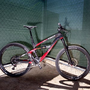 Spot Brand Bicycles has been building bikes since 1999 and their new Rollik 557 Mountain bike is their first carbon bicycle ever. The weren't messing around when they dove into carbon as they have even replaced their lower rear pivot bearings with a piece of carbon, or composite leaf spring to be exact. They claim their Living Link rear pivot eliminates movement, makes a bike with great small bump compliance and great for the big hits and decreases weight and maintanence.