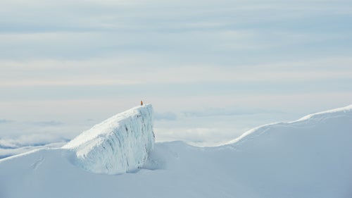 At over 9,000 feet tall, Mount Ruapehu is the highest point on the North Island and the largest active volcano in the country. It鈥檚 made up of three separate peaks, including Mount Ngauruhoe, known as Mount Doom in the Lord of the Rings. The mountain is home to two different ski resorts, Whakapapa and Turoa.
At sunrise, Lolos and a guide from Whakapapa Ski Area rode a snowcat up the mountain as far as it could go. Then, the two continued to hike two hours up to the crater, carrying their skis. At the top, the guide stood on the side of the crater while Lolos took this picture.